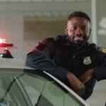 a police officer leaning on a car